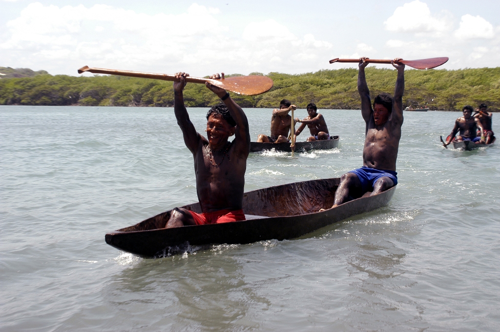 Índios em canoa comemorando